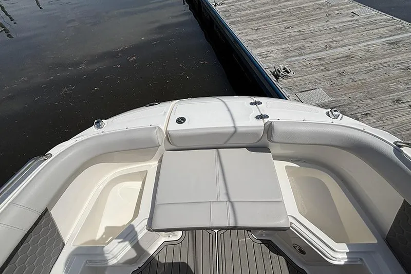 Slide: The Image of 2024 Sea Ray SDX 250 Outboard boat interior with seating, docked by wooden pier. - 24