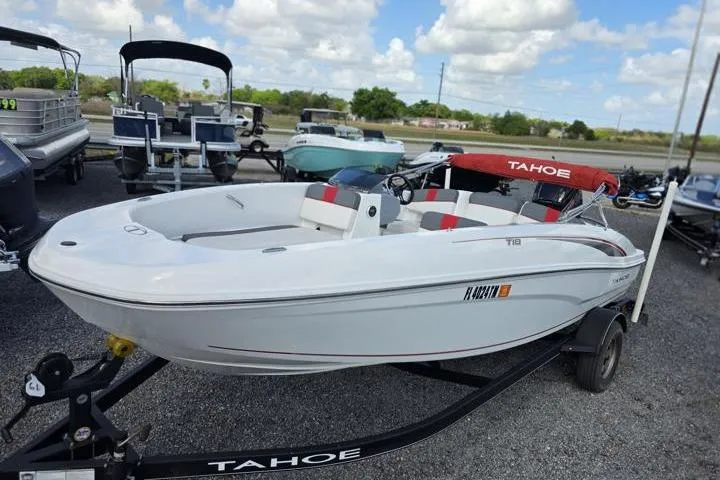 The Image of 2022 Tahoe T18 boat on trailer, white with red accents, parked outdoors. - 1