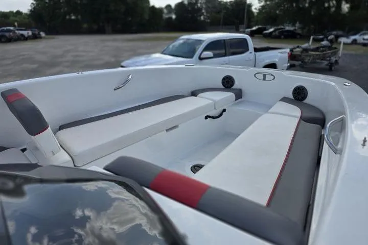 Slide: The Image of 2022 Tahoe T18 boat interior with white and gray seating, parked near a white truck. - 10
