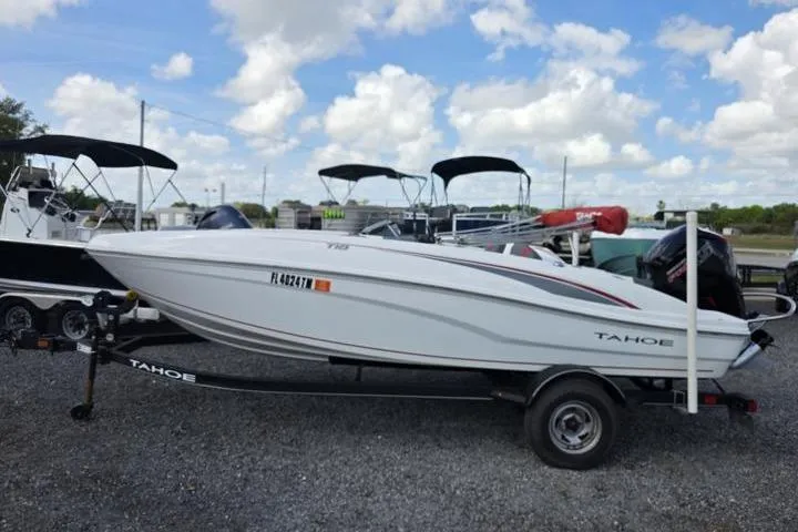Slide: The Image of 2022 Tahoe T18 boat on trailer under a partly cloudy sky. - 2