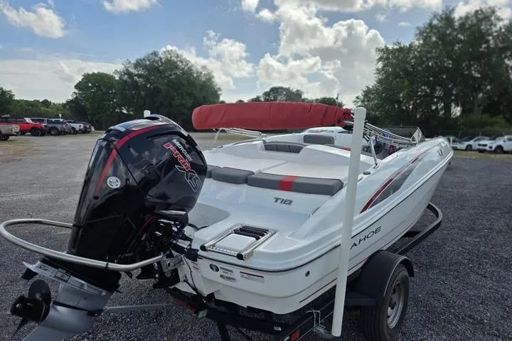 Slide: The Image of 2022 Tahoe T18 boat on trailer with outboard motor, parked outdoors under cloudy sky. - 4