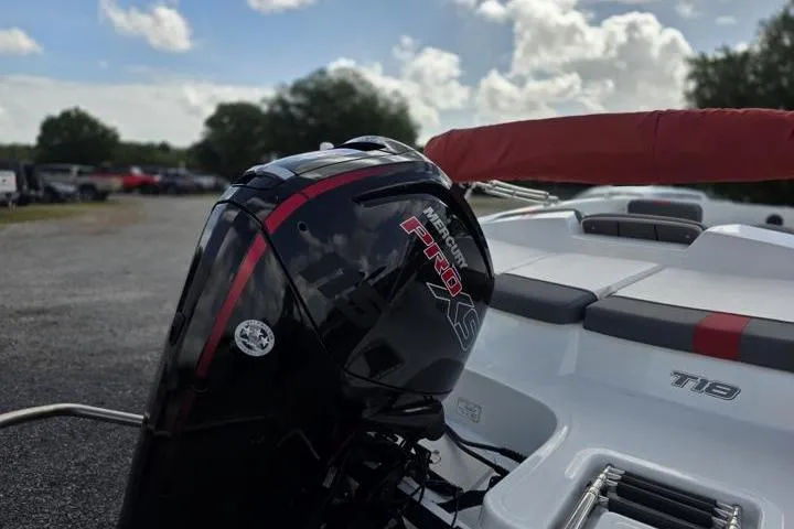 Slide: The Image of 2022 Tahoe T18 boat with Mercury Pro XS engine, parked outdoors under a cloudy sky. - 5