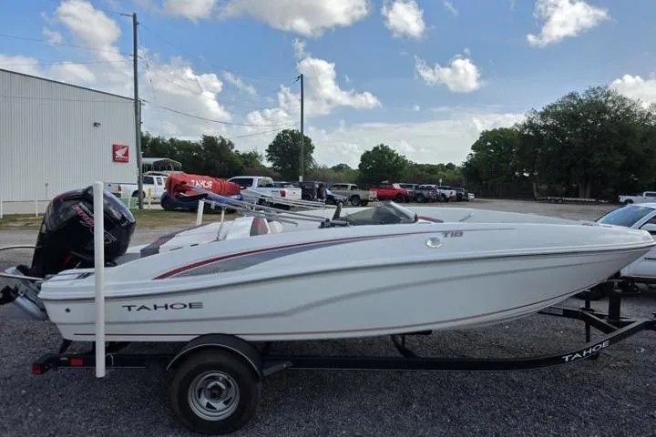 Slide: The Image of 2022 Tahoe T18 boat on trailer in outdoor lot under blue sky. - 6