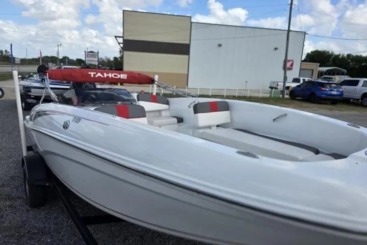 Slide: The Image of 2022 Tahoe T18 boat with red canopy, parked outdoors on a trailer. - 7