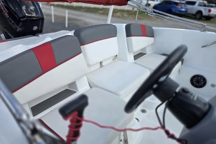 Slide: The Image of 2022 Tahoe T18 boat interior with red and gray seating, steering wheel, and controls. - 9