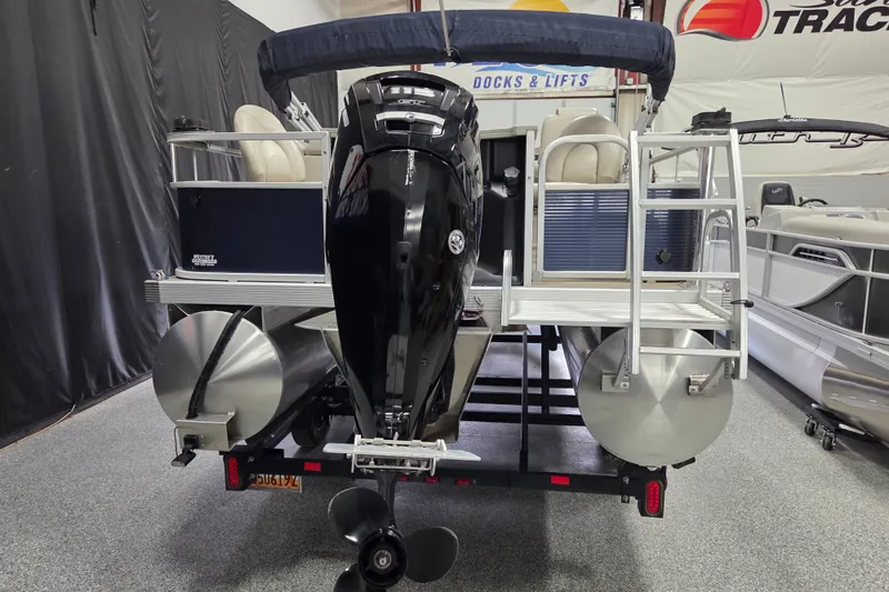 Slide: The Image of 2018 Bennington 22SFX pontoon boat with outboard motor, displayed indoors on a trailer. - 4