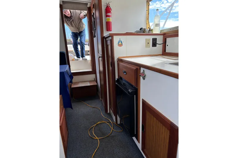 Slide: The Image of Interior of a 1973 Luhrs 28 boat with kitchenette and fire extinguisher. - 11