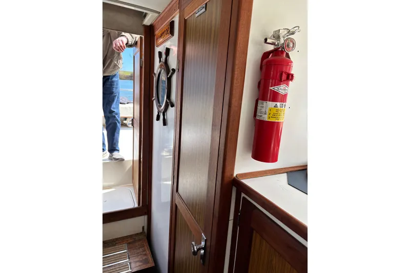 Slide: The Image of 1973 Luhrs 28 boat interior with fire extinguisher and wooden door. - 12