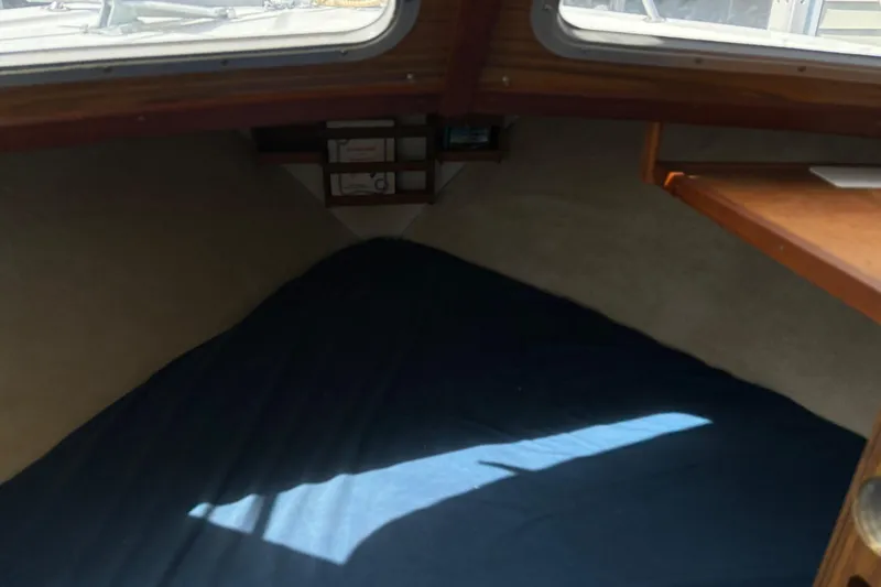 Slide: The Image of Interior cabin of a 1973 Luhrs 28 boat with blue bedding and wooden accents. - 13