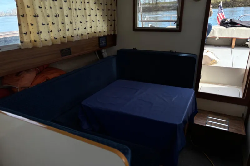 Slide: The Image of Interior of a 1973 Luhrs 28 boat with a cozy dining area and window view. - 14
