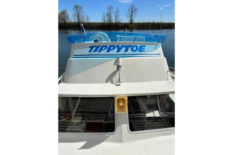 Slide: The Image of 1973 Luhrs 28 boat named "Tippytoe" docked on a calm river with clear skies. - 19