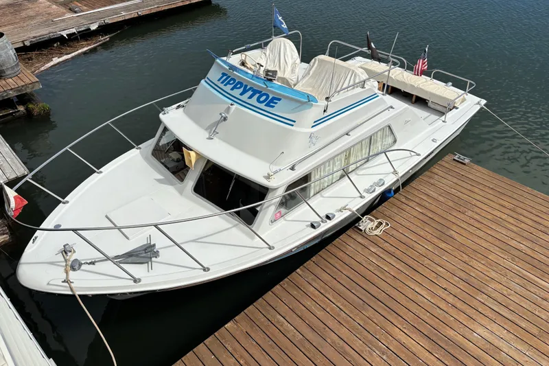 Slide: The Image of 1973 Luhrs 28 boat docked, featuring a white exterior and blue accents. - 2