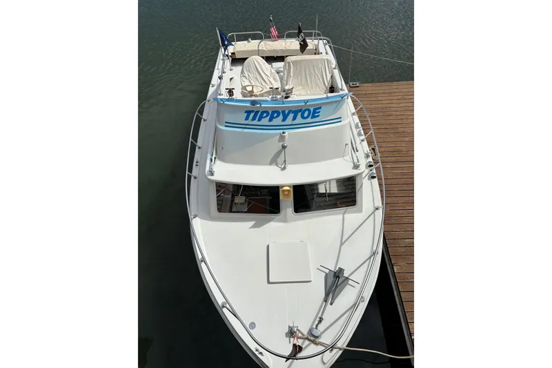 Slide: The Image of 1973 Luhrs 28 boat named "Tippytoe" docked on calm water. - 21