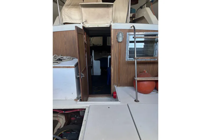 Slide: The Image of 1973 Luhrs 28 boat interior with open cabin door and nautical equipment. - 23