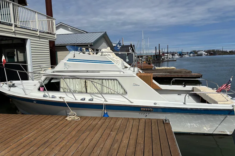 Slide: The Image of 1973 Luhrs 28 boat docked at marina, featuring classic design and American flag. - 3