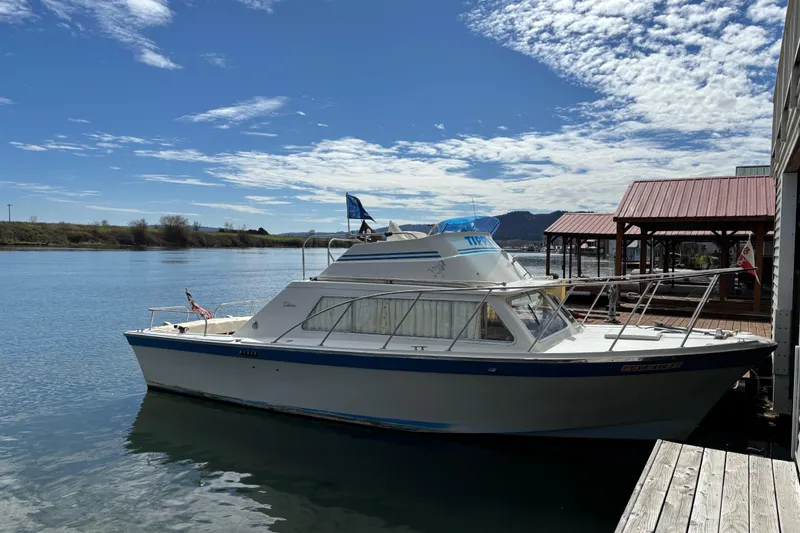 Slide: The Image of 1973 Luhrs 28 boat docked by a wooden pier under a partly cloudy sky. - 4