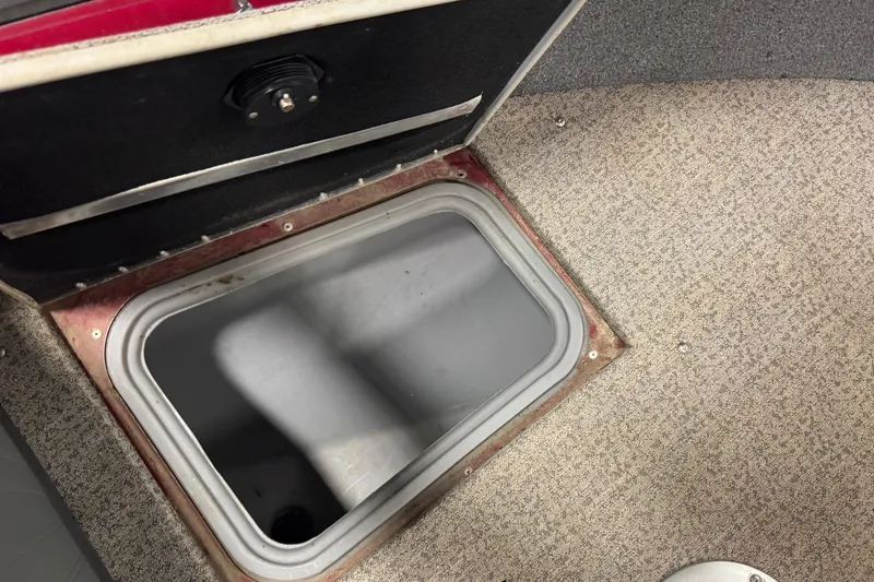 Slide: The Image of Storage compartment in 2022 Tracker Targa V-18 WT boat, featuring carpeted interior. - 12