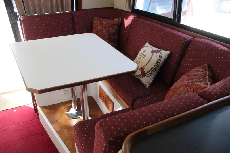 Slide: The Image of Interior of 1985 Carver 32 Convertible with red cushioned seating and white table. - 12