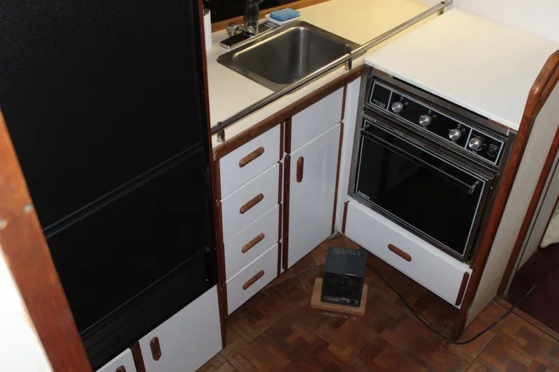 Slide: The Image of Compact kitchen area in a 1985 Carver 32 Convertible boat with sink and oven. - 16