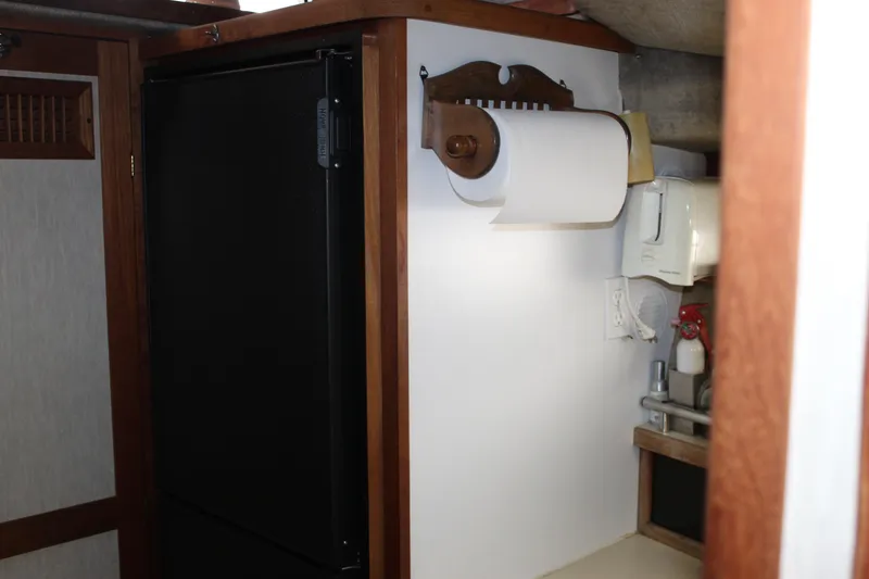 Slide: The Image of Interior of 1985 Carver 32 Convertible with paper towel holder and black refrigerator. - 18