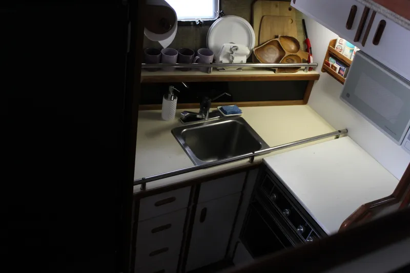Slide: The Image of Compact kitchen area in a 1985 Carver 32 Convertible boat, featuring a sink and stove. - 19