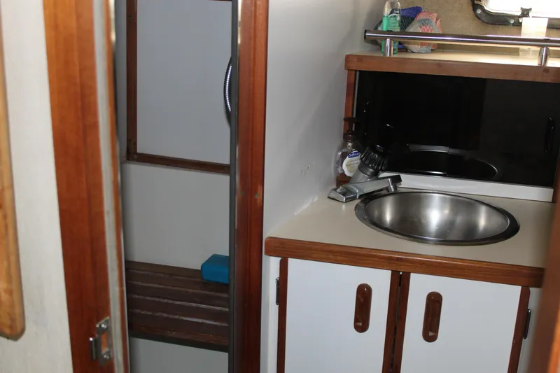 Slide: The Image of 1985 Carver 32 Convertible boat bathroom with sink and shower area. - 20