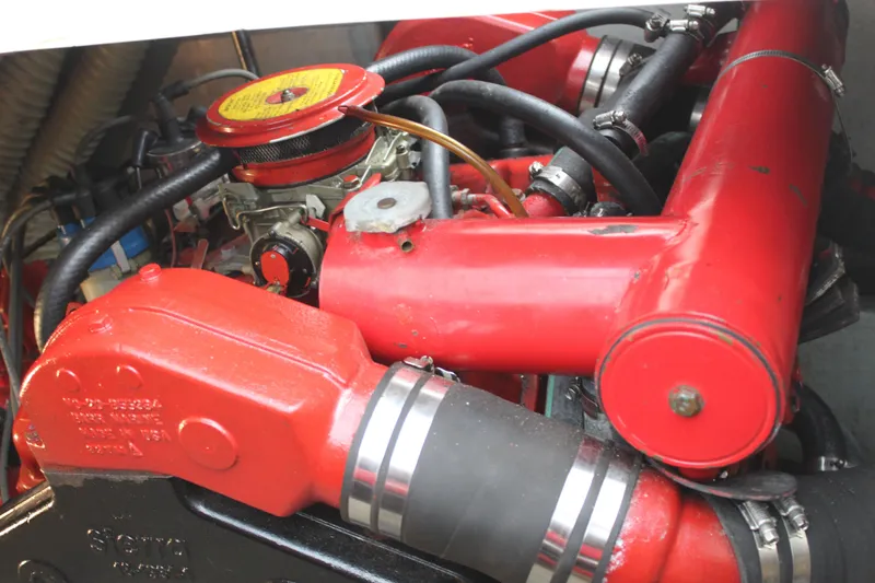 Slide: The Image of Engine components of a 1985 Carver 32 Convertible, featuring red pipes and hoses. - 25