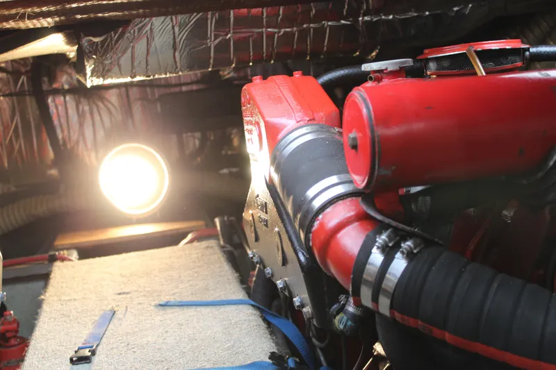 Slide: The Image of Engine room of a 1985 Carver 32 Convertible with red components and bright lighting. - 26