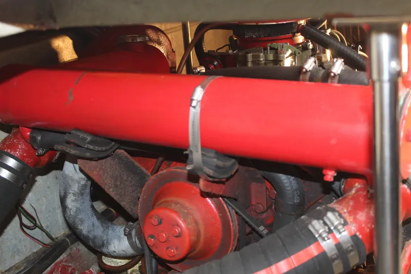 Slide: The Image of Engine compartment of a 1985 Carver 32 Convertible boat, featuring red components and hoses. - 27