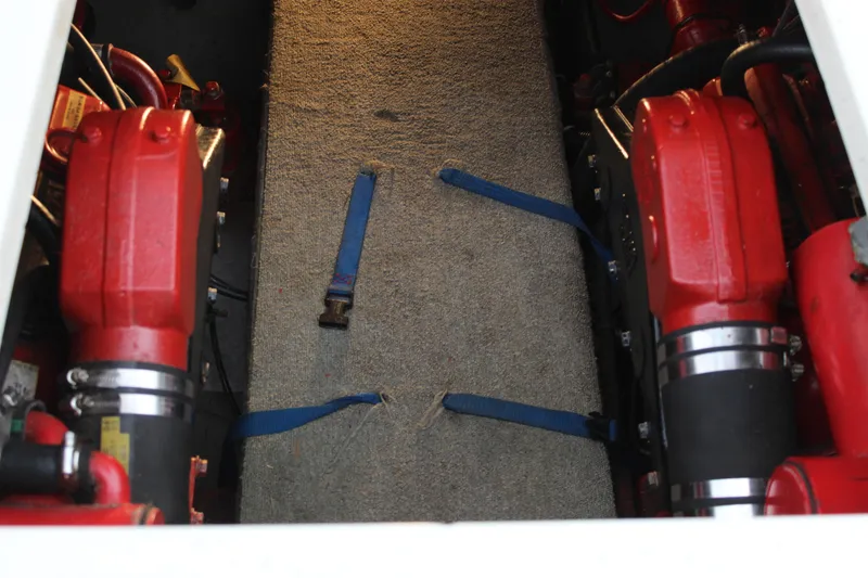 Slide: The Image of Engine compartment of a 1985 Carver 32 Convertible boat with red components. - 28