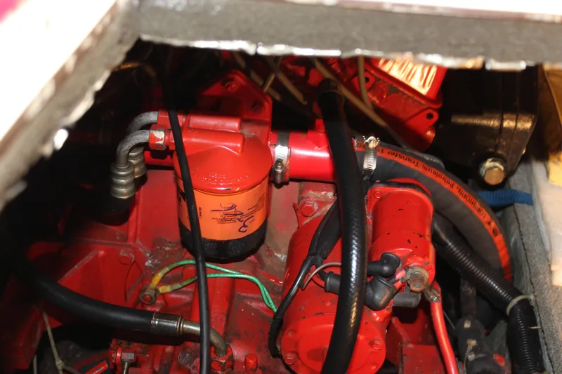 Slide: The Image of Engine compartment of a 1985 Carver 32 Convertible boat, featuring red components and hoses. - 29