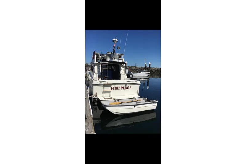 Slide: The Image of 1985 Carver 32 Convertible boat docked in a marina, clear blue sky. - 3