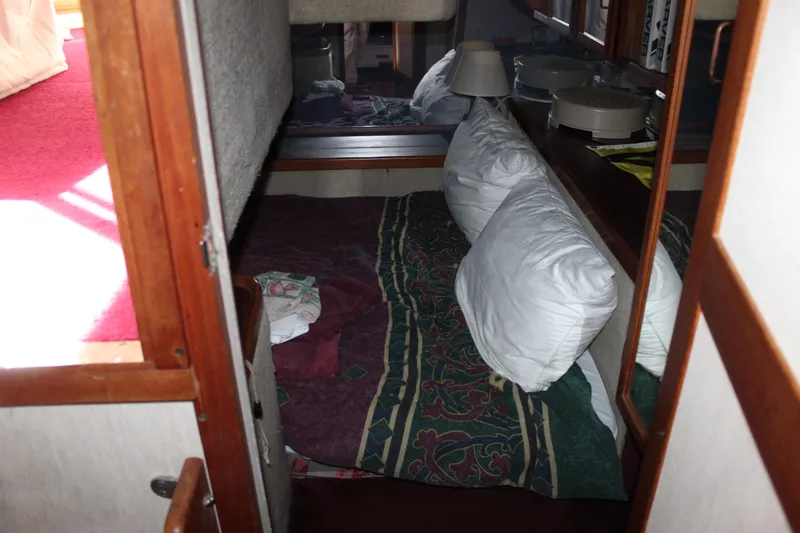 Slide: The Image of Cozy cabin interior of 1985 Carver 32 Convertible with pillows and patterned bedding. - 33