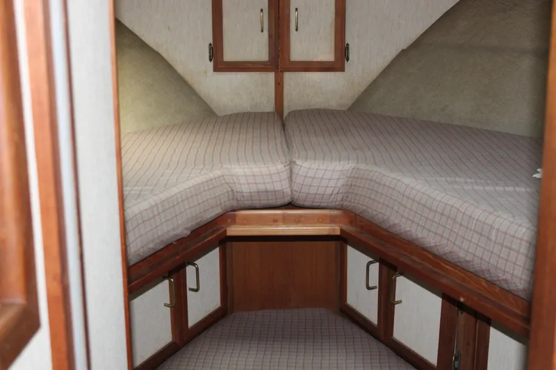 Slide: The Image of 1985 Carver 32 Convertible cabin interior with V-berth and wooden storage cabinets. - 35