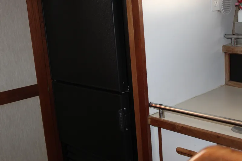 Slide: The Image of Interior of 1985 Carver 32 Convertible, featuring a compact kitchen area with a black appliance. - 36