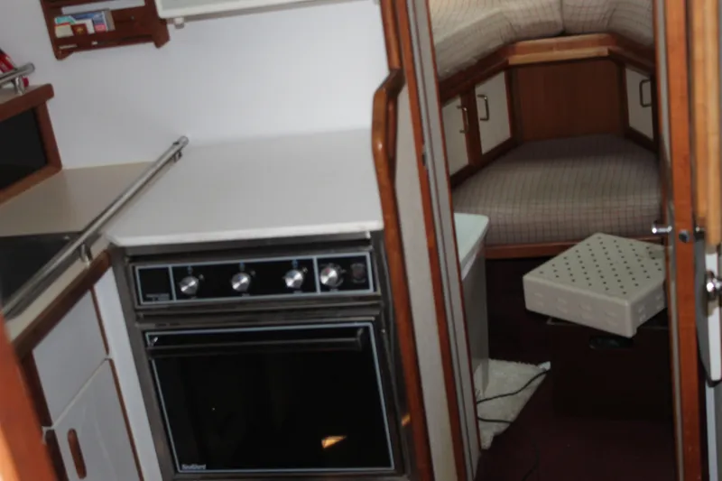 Slide: The Image of Interior of 1985 Carver 32 Convertible boat, featuring kitchen and sleeping area. - 37