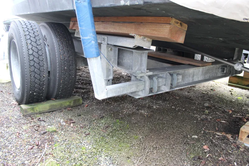 Slide: The Image of Trailer supporting a 1985 Carver 32 Convertible boat, showing dual wheels and wooden blocks. - 6