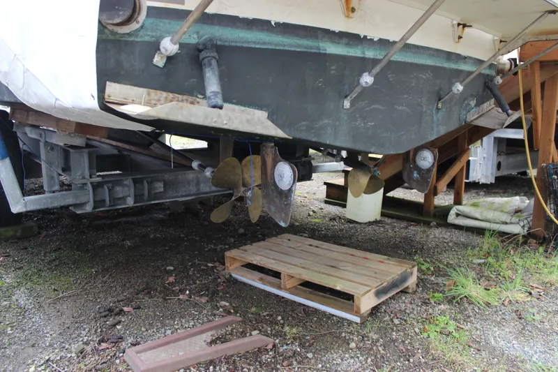 Slide: The Image of 1985 Carver 32 Convertible boat on dry dock, showing propellers and hull. - 8