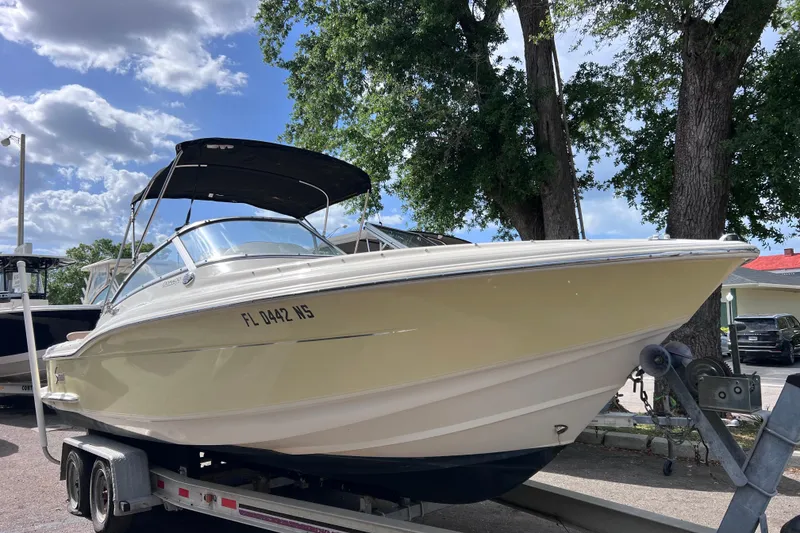 Slide: The Image of 2008 Scout 222 Dorado boat on trailer under blue sky and trees. - 1