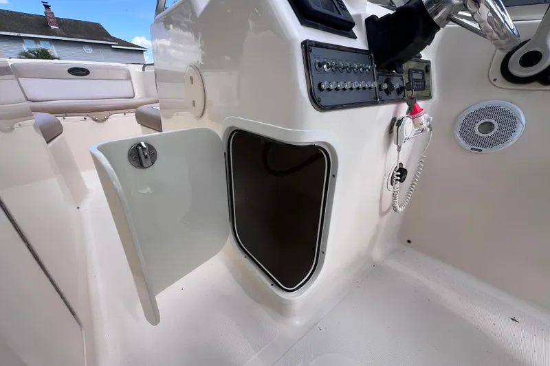 Slide: The Image of 2008 Scout 222 Dorado boat interior with open storage compartment and control panel. - 31