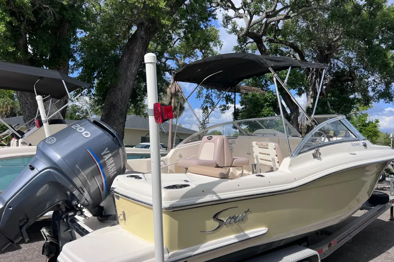 Slide: The Image of 2008 Scout 222 Dorado boat with Yamaha 200 engine, parked under trees. - 4