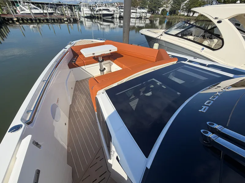 Slide: The Image of 2027 Saxdor 400 GTC with stylish deck and orange seating, docked at a marina. - 25
