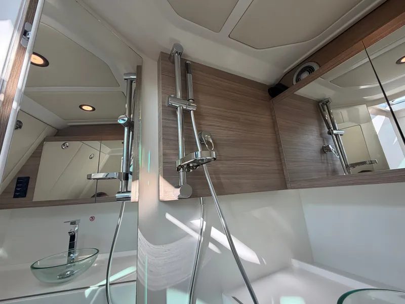 Slide: The Image of The image shows a modern boat bathroom with glass sink and shower fixtures. - 46