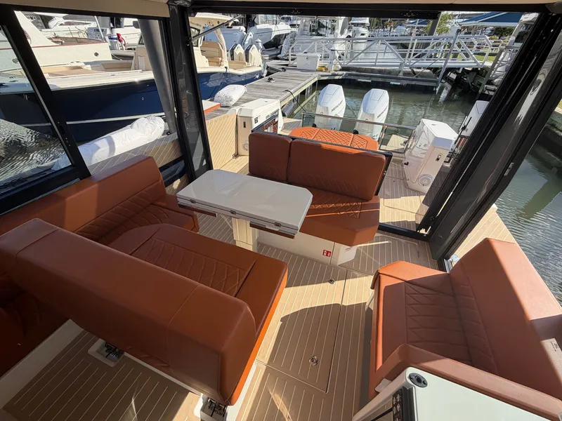 Slide: The Image of Interior of the Saxdor 400 GTC with brown leather seating and a table, docked at a marina. - 9