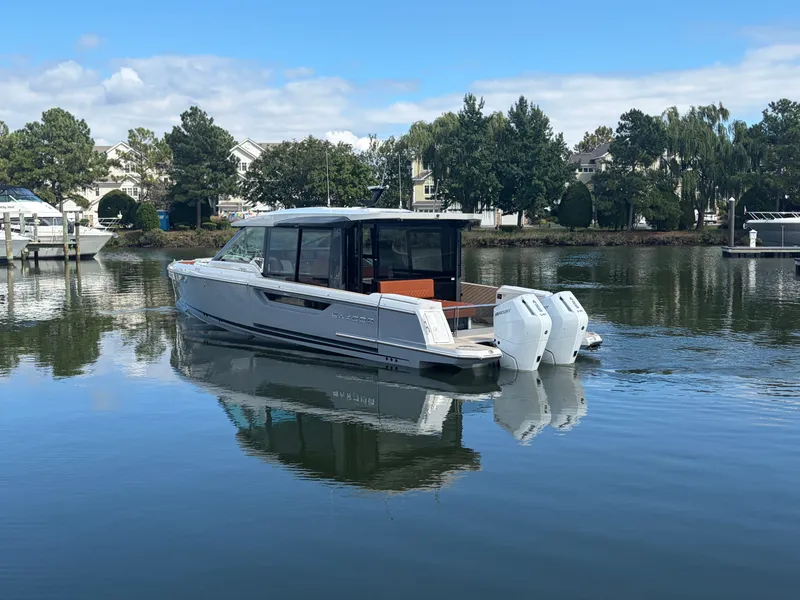 Slide: The Image of A 2027 Saxdor 400 GTC on calm water, surrounded by trees and houses. - 5