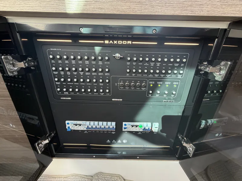Slide: The Image of The image shows a control panel with numerous switches and indicators on a Saxdor 400 GTC boat. - 40