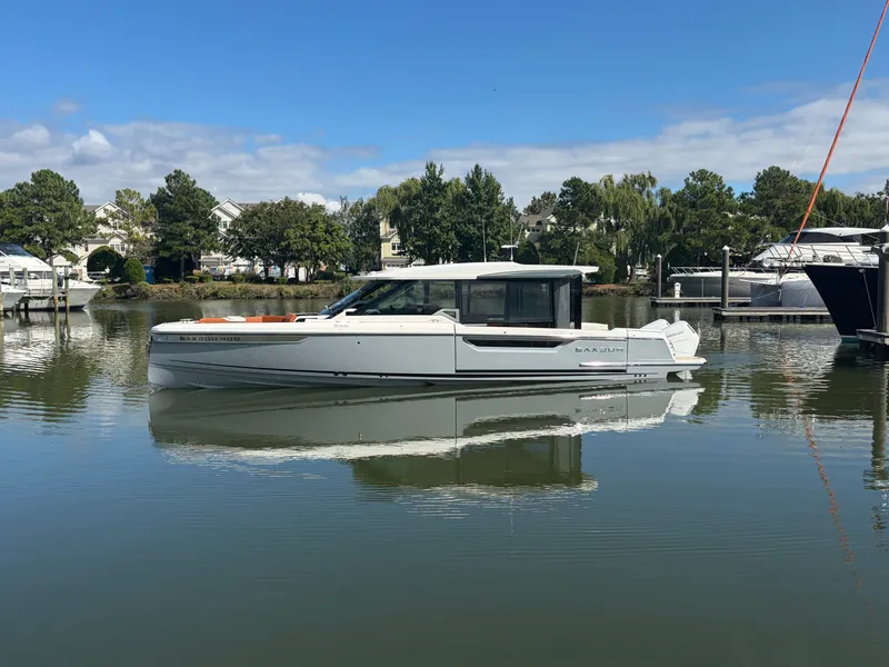 Slide: The Image of A modern Saxdor 400 GTC boat sits calmly on the water, surrounded by trees and other boats. - 4