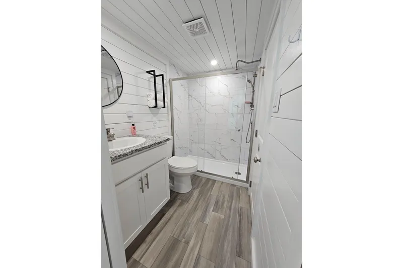 Slide: The Image of Modern houseboat bathroom with shower, vanity, and wood flooring, 2025 float house model. - 10