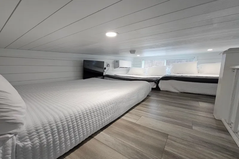 Slide: The Image of Modern 2025 houseboat interior with cozy beds, white decor, and natural light. - 15