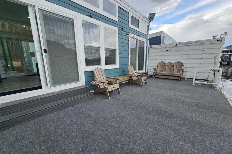 Slide: The Image of Modern 2025 houseboat with spacious deck, Adirondack chairs, and large windows. - 19